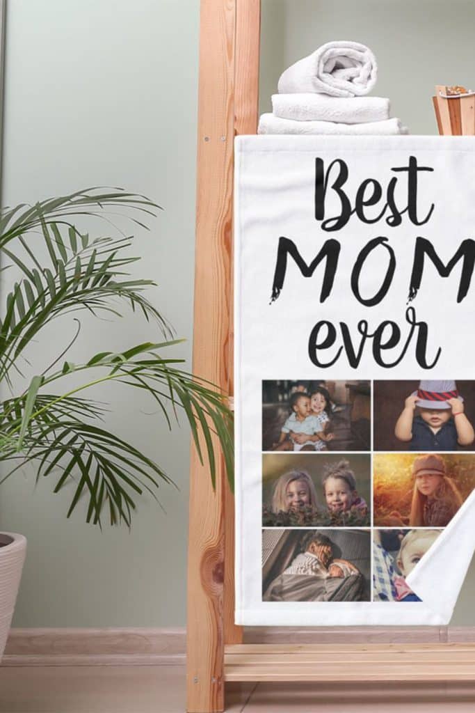 White Towel With “Best Mom Ever” Text And Six Personal Family Photos Printed In A Vertical Collage—Displayed On A Wooden Towel Rack.