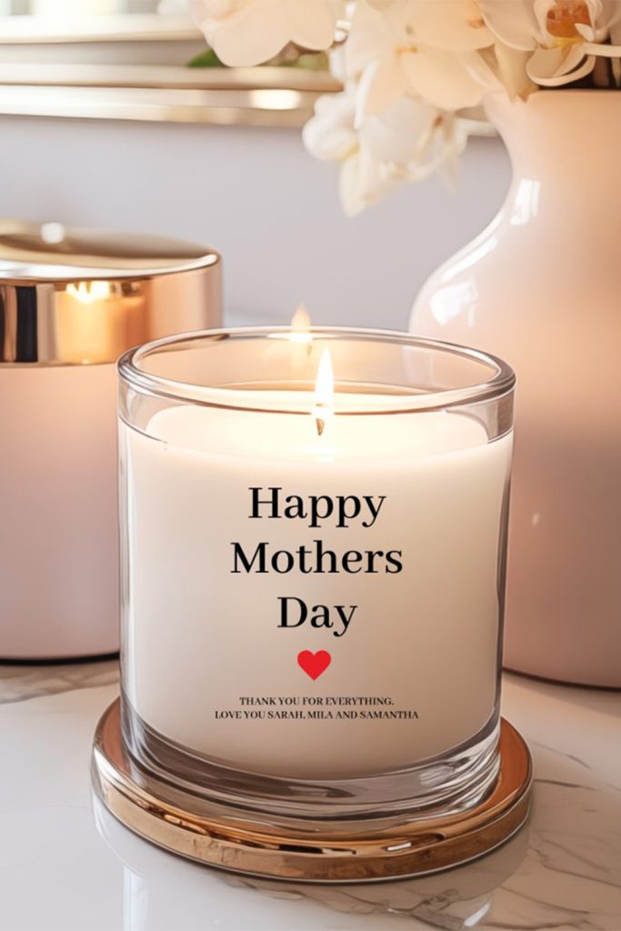 White Glass Candle With “Happy Mothers Day” And A Custom Note From Children, Sitting On A Marble Counter Surrounded By Soft Pink And Gold Decor.