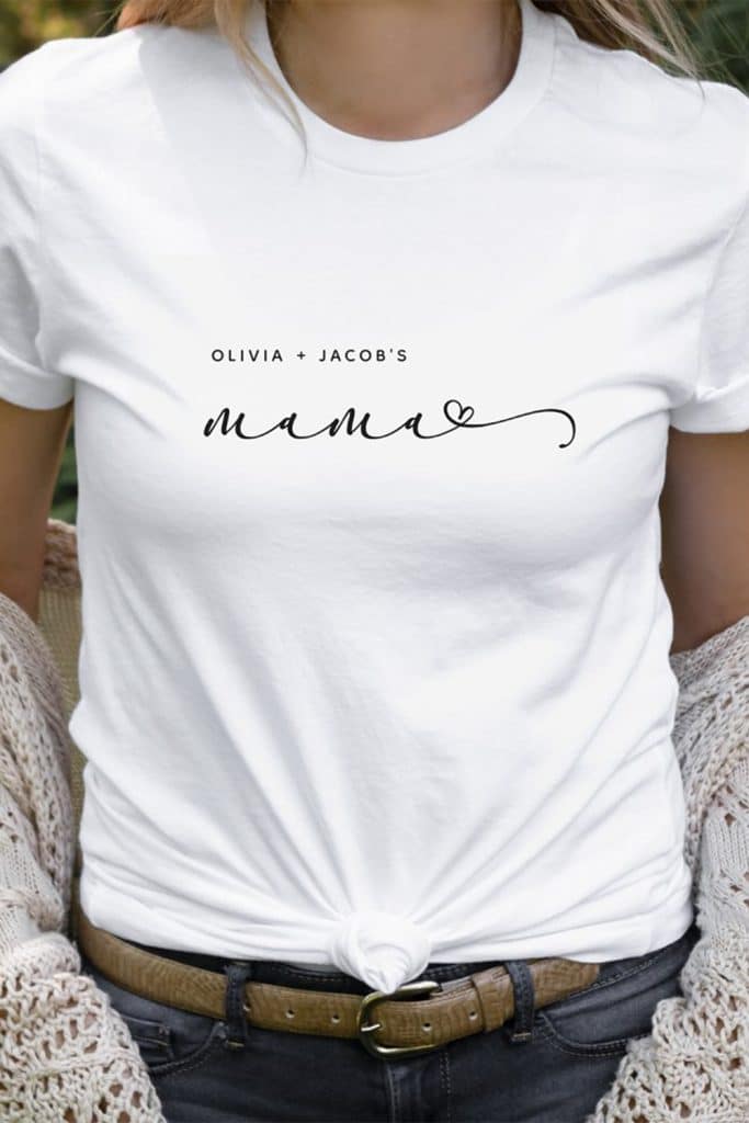 White T-Shirt With Minimalist Black Script Reading “Olivia + Jacob’s Mama” And A Heart Accent—Stylish And Sentimental Custom Gift For Mom.