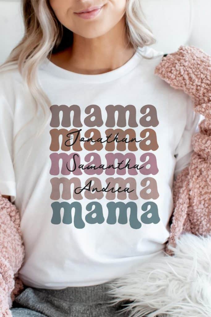 White T-Shirt With Retro Stacked “Mama” Text In Neutral Tones, Personalized With The Names Jonathan, Samantha, And Andrea In Script—Perfect Mother’s Day Gift.