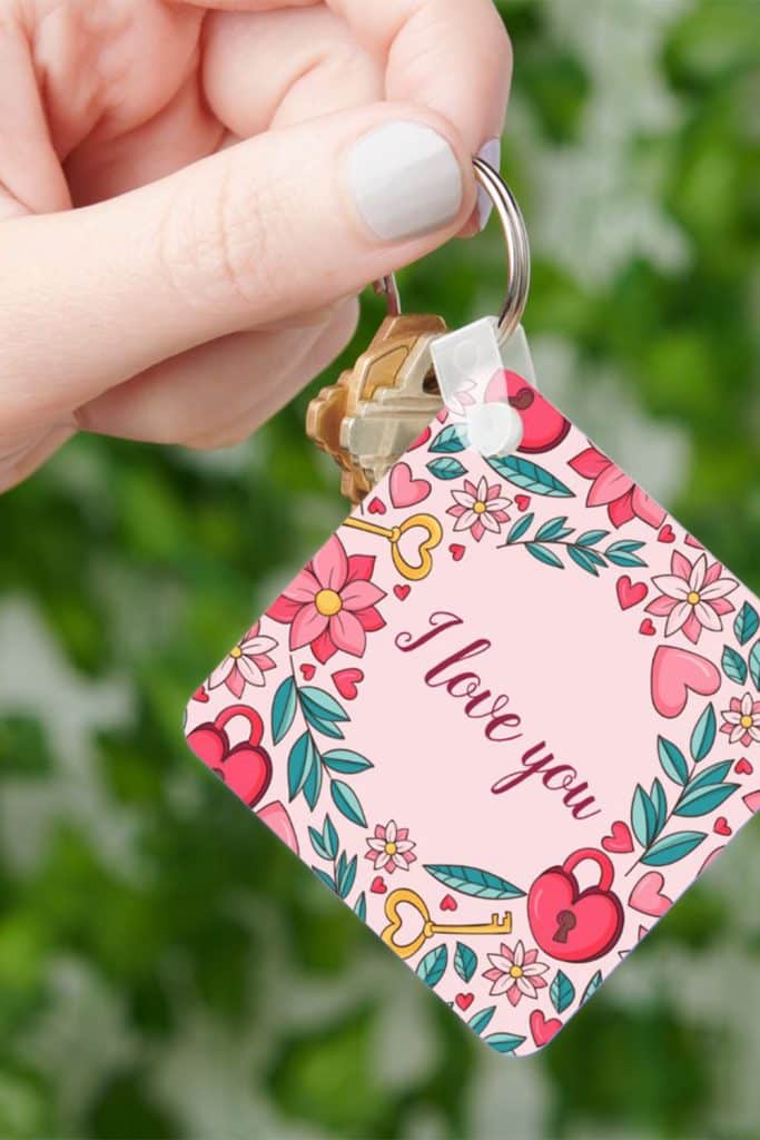 Square Pink Keychain With “I Love You” Surrounded By Floral Hearts And Whimsical Designs—Charming And Colorful Mother’s Day Accessory.