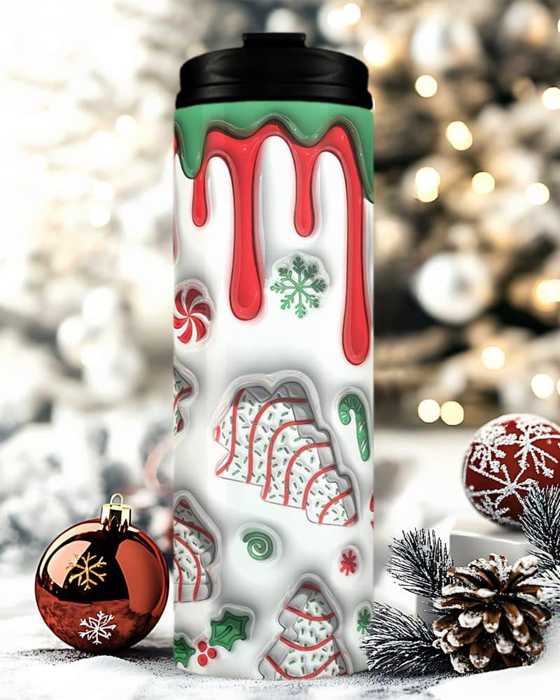 Christmas-themed travel mug with red and green dripping icing design and cookie decorations.
