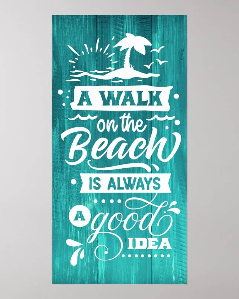 Teal wood sign with white lettering that reads, A walk on the beach is always a good idea. A small beach scene with a palm tree is above the text.