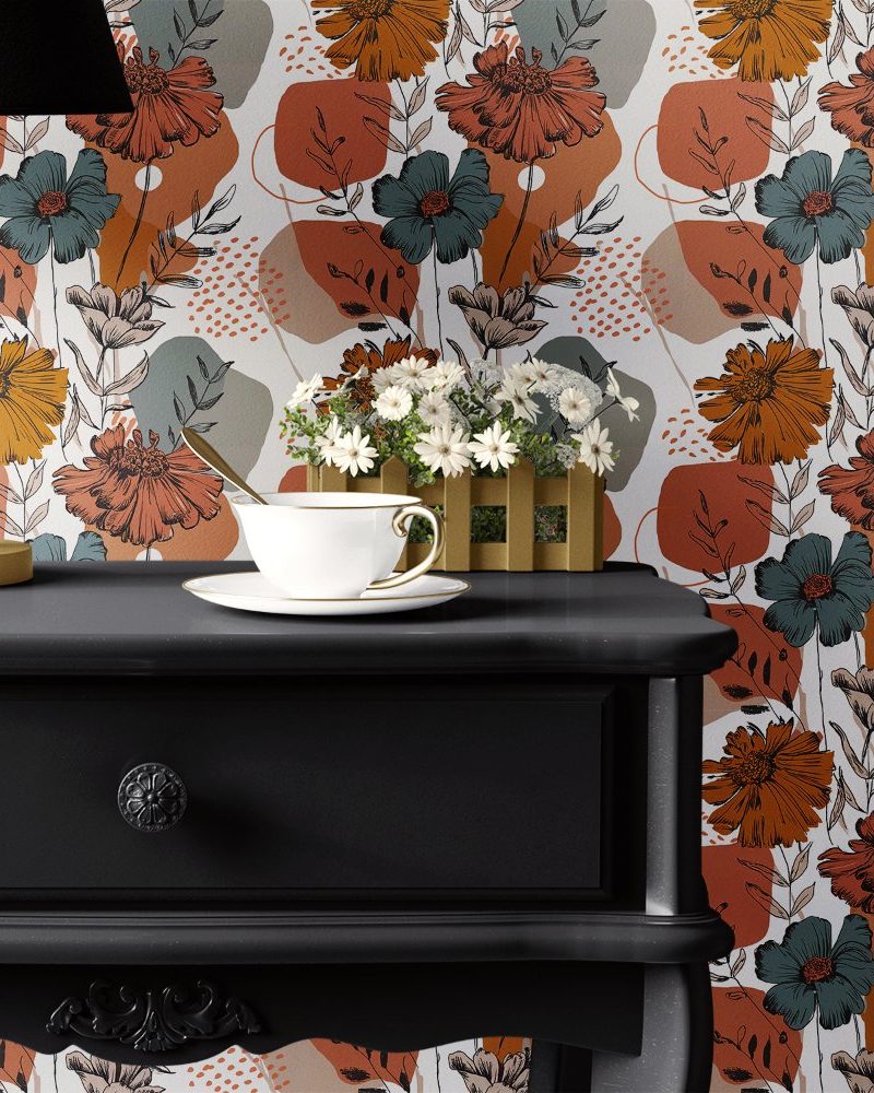 Black dresser with teacup and saucer on top, set against a floral wallpaper featuring orange, teal, and gray flowers.