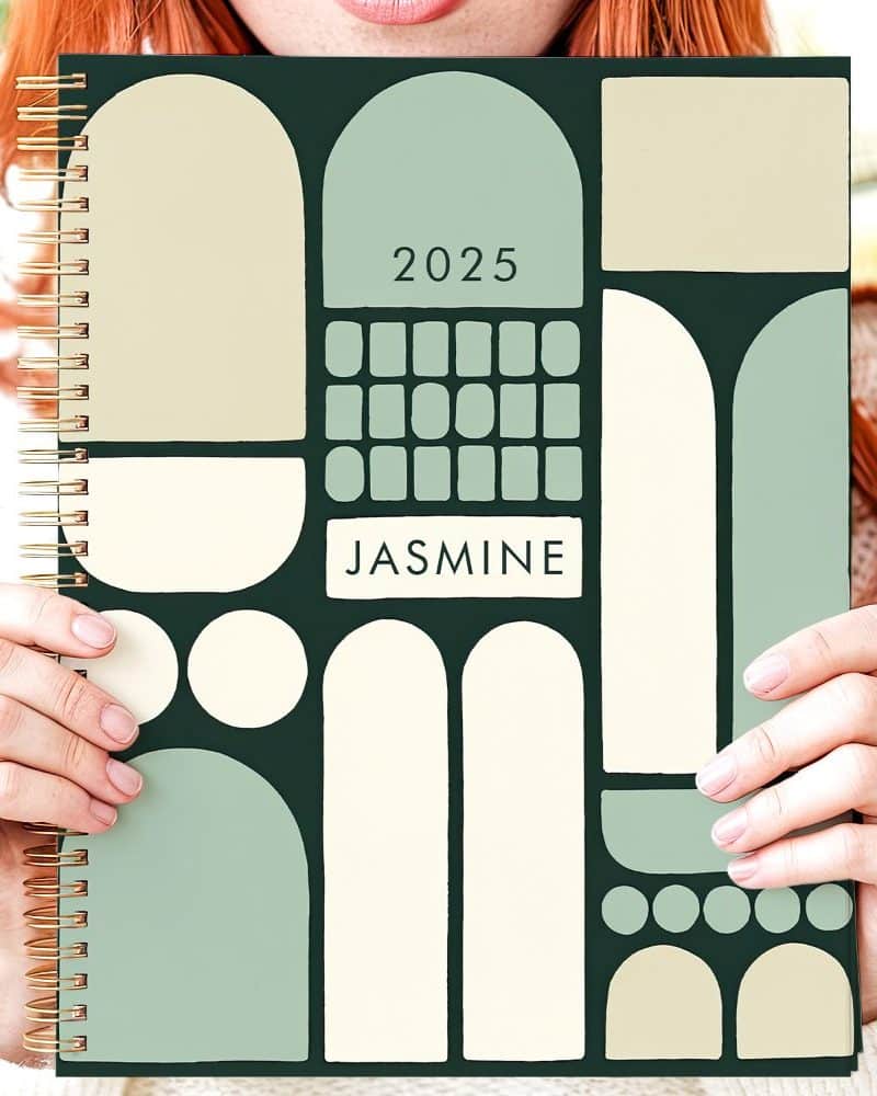 Person holding a 2025 planner with a green and beige abstract design and the name Jasmine.