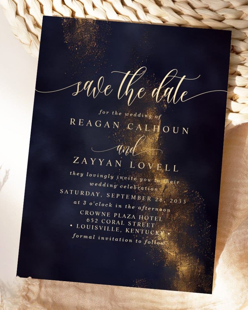 Navy blue save-the-date announcement with gold lettering for the wedding of Reagan Calhoun and Zayyan Lovell.