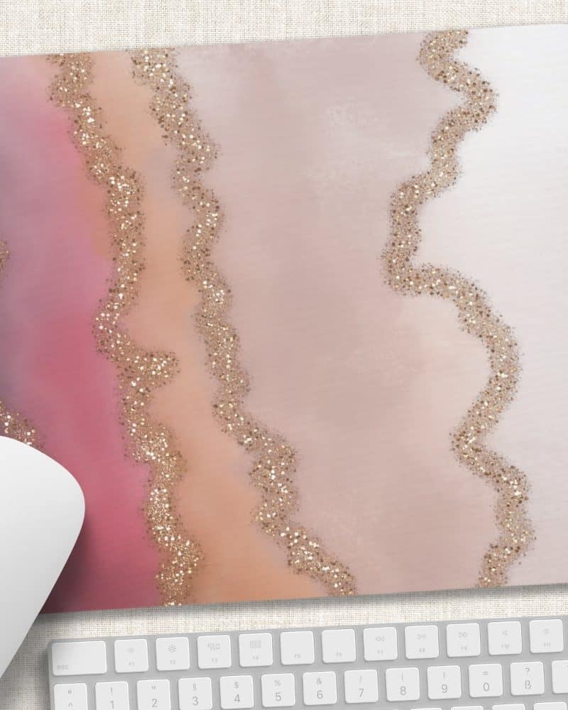 Mousepad with a pink, peach, and beige agate design featuring gold glitter accents.
