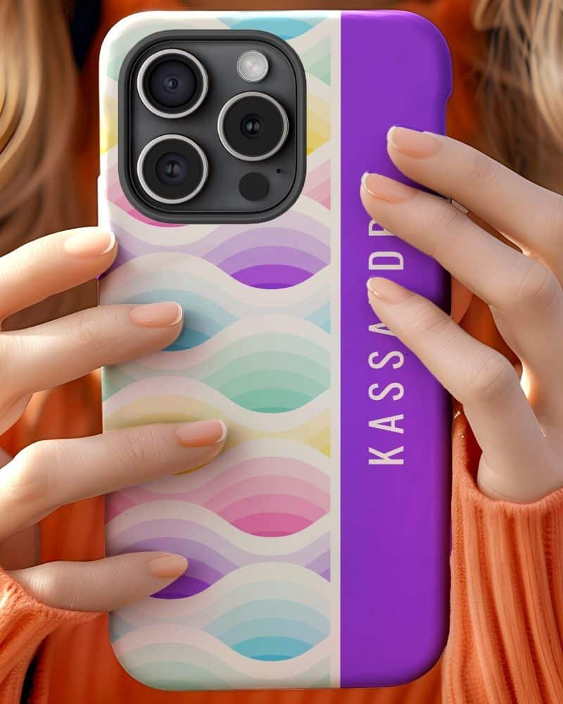 Woman's hands holding a pastel wave patterned phone case with a purple personalized stripe.