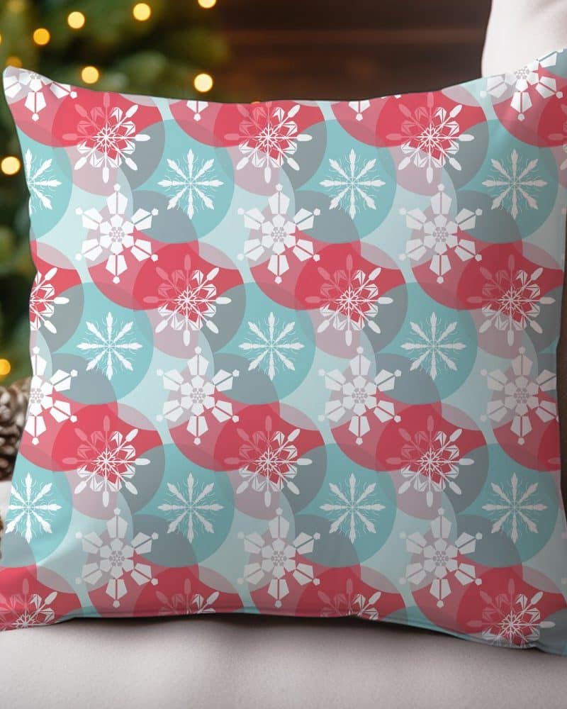 Decorative throw pillow with a repeating snowflake pattern in red and teal.