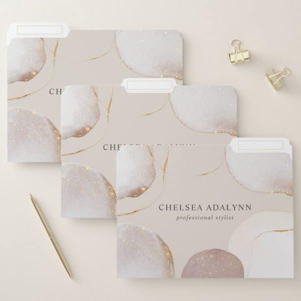 Three File Folders With A Beige Background And Sparkly, Abstract Shapes In Shades Of White And Pink. Gold Lines Accent The Design. The Bottom Folder Is Labeled Chelsea Adalynn, Professional Stylist.