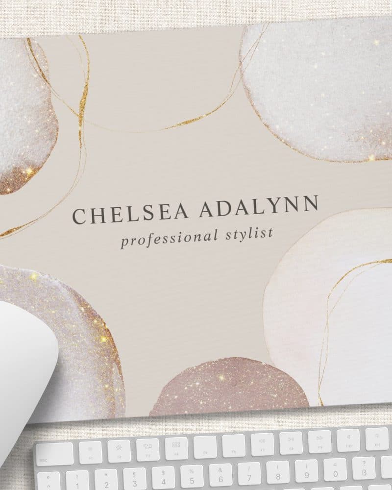 Mousepad featuring the name Chelsea Adalynn, professional stylist, on a beige background with abstract gold and glitter shapes.