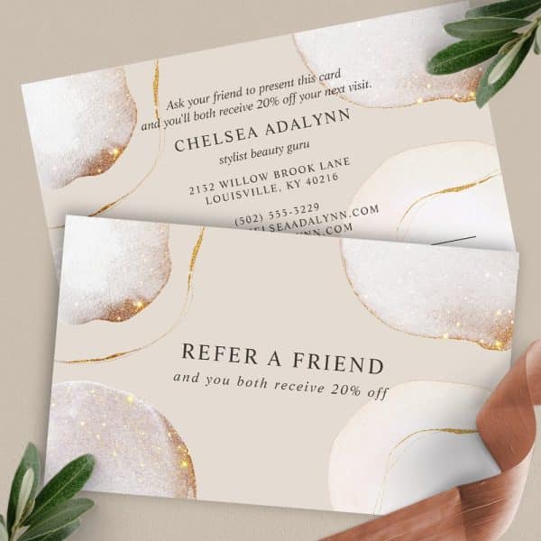 Two Beige Referral Cards With Gold-Glitter Abstract Designs. The Top Card Advertises Chelsea Adalynn, Stylist, And The Bottom Card Encourages Referring A Friend For A Discount.