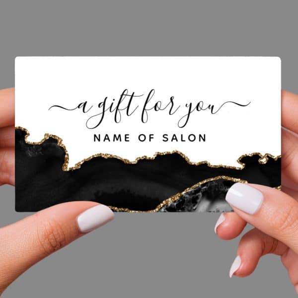 Hands Holding A Black And Gold Gift Certificate With Elegant Script That Says A Gift For You.