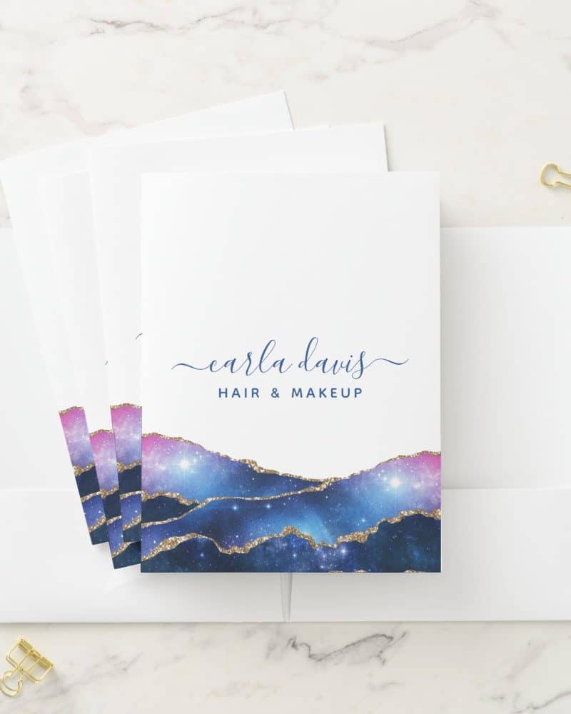 Stack of business cards with a galaxy design and Carla Davis Hair & Makeup text.