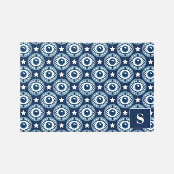 Blue And White Patterned Doormat With Repeating Evil Eye Motifs And Stars. A Navy Blue Square With A White &Quot;S&Quot; Is In The Bottom Right Corner.