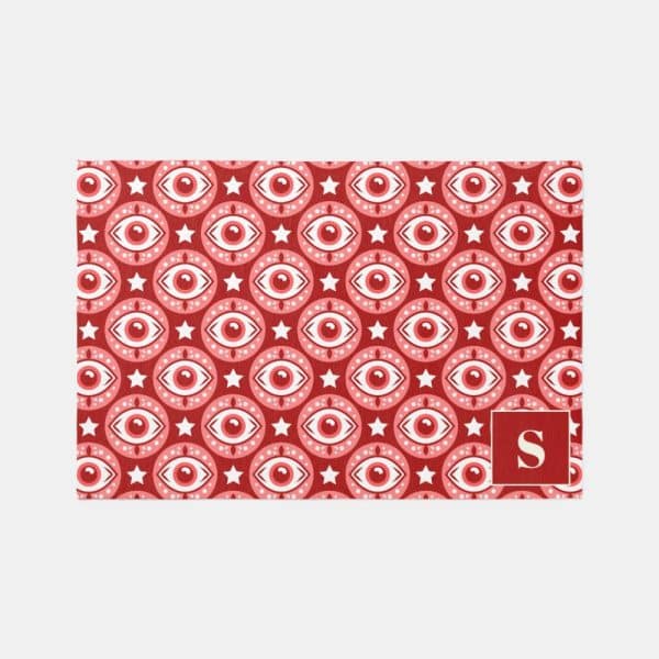 Red Doormat With Repeating Pattern Of Pink Eyes And White Stars.