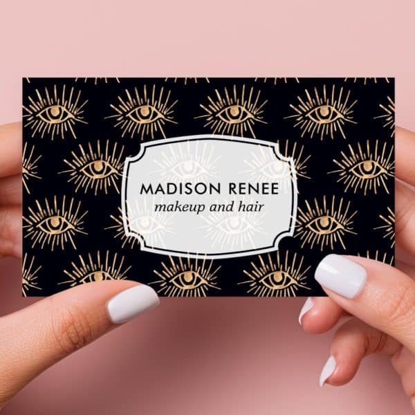 Business Card With A Black Background And Gold Eye Pattern; Madison Renee Makeup And Hair.