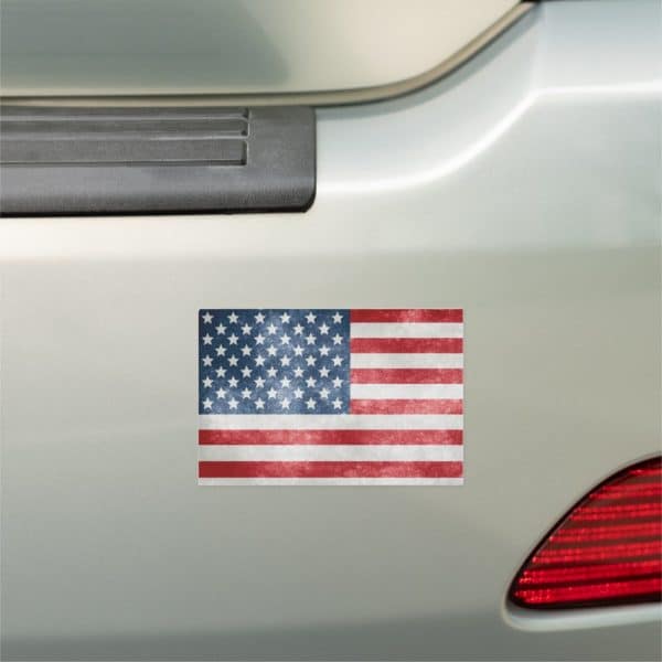 Distressed American Flag Sticker On A Car Bumper.