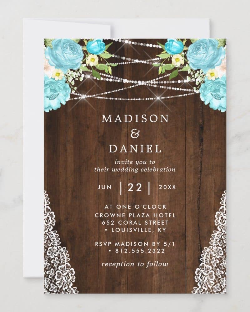 Rustic wedding invitation with light blue flowers, string lights, and white lace accents.
