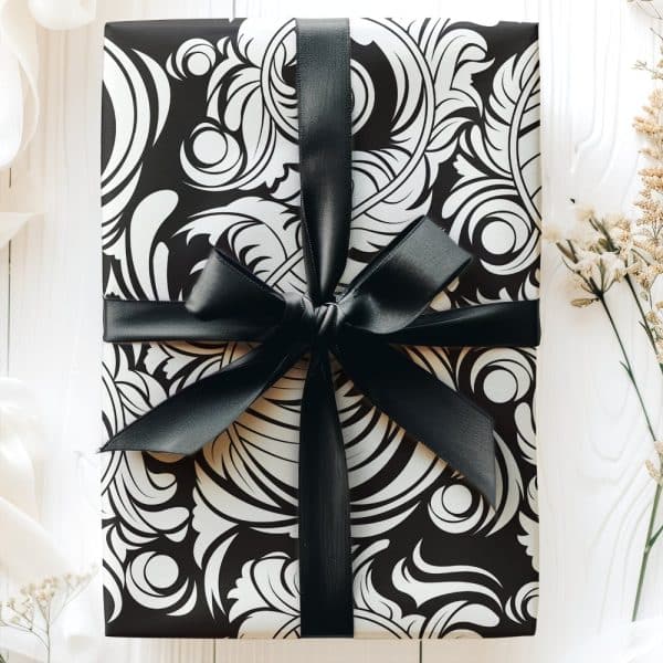 A Gift Wrapped In Black And White Patterned Paper With A Black Ribbon.