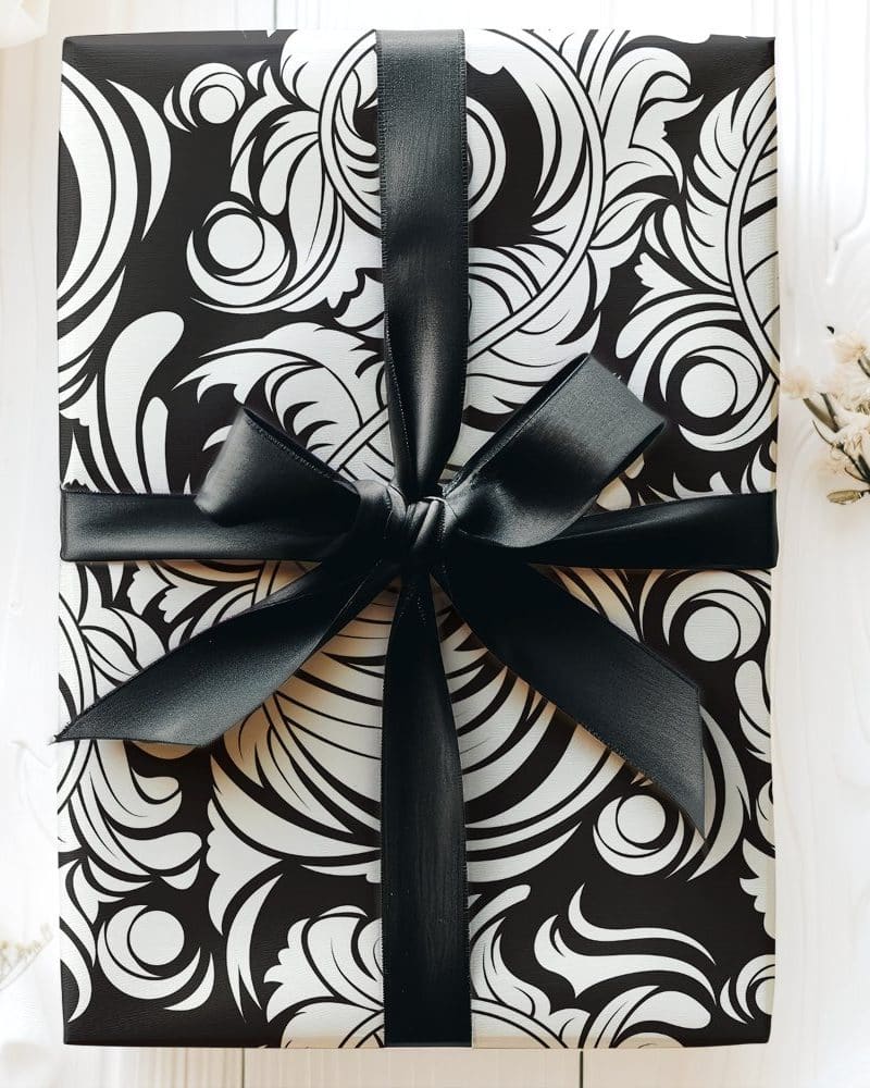 A gift wrapped in black and white patterned paper with a black ribbon.