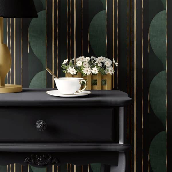 A Black Nightstand With A Teacup And Saucer, And A Small Plant In A Wooden Box Sits In Front Of A Dark Green And Gold Patterned Wall.