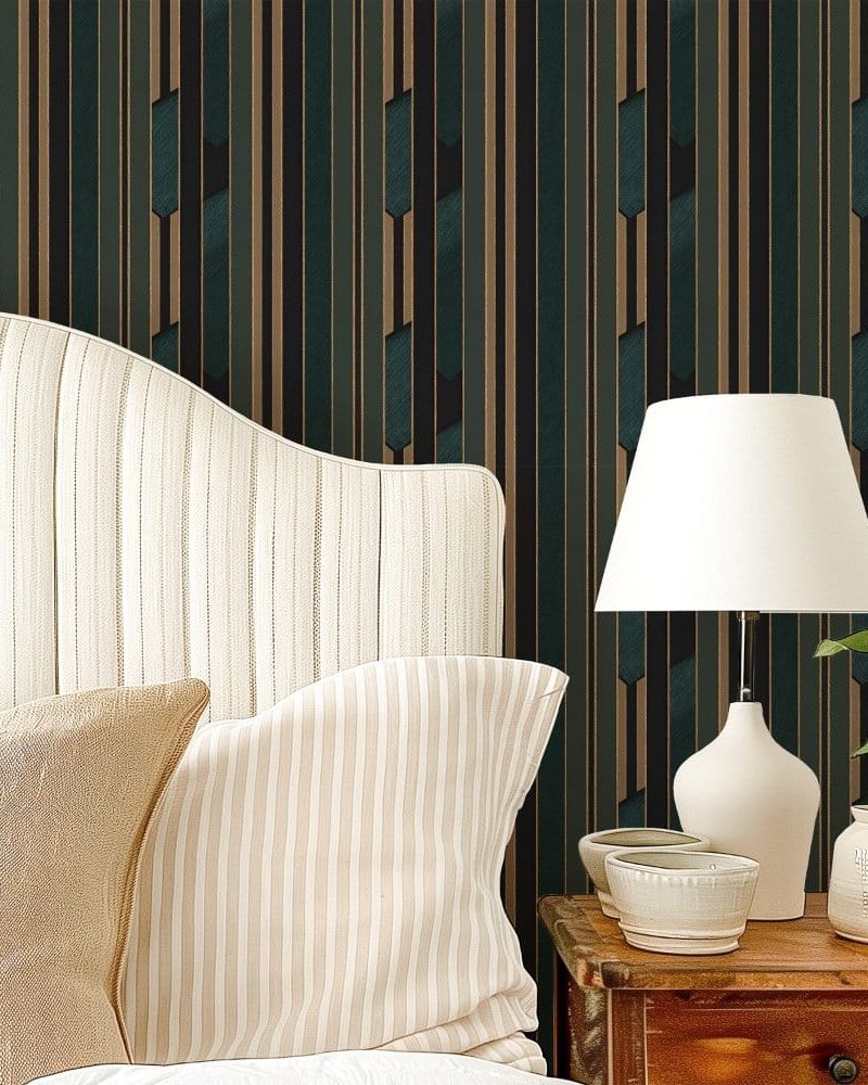 A beige striped headboard with matching pillows sits against a wall with dark teal and gold striped wallpaper.
