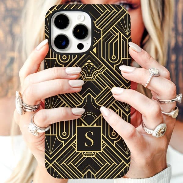 Hands Holding A Black Iphone Case With A Gold Art Deco Design And The Initial S.