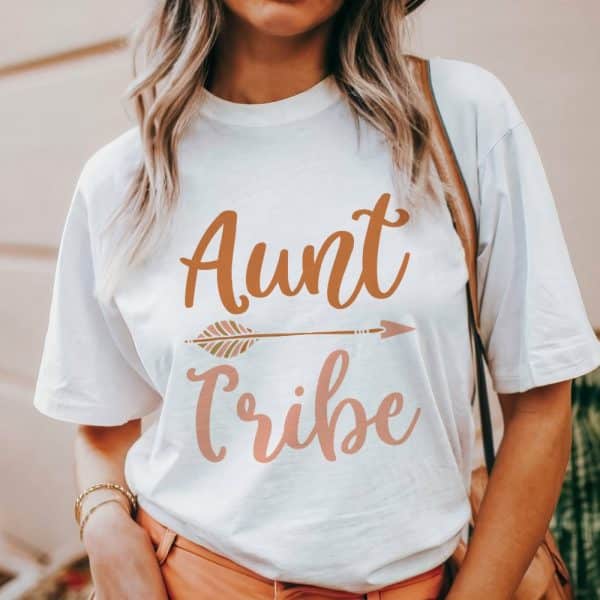Woman Wearing A White T-Shirt That Says Aunt Tribe In A Boho Font With An Arrow Graphic.