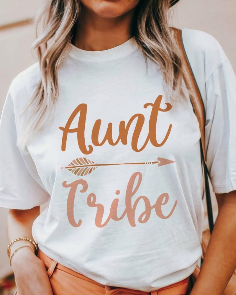 Woman wearing a white t-shirt that says Aunt Tribe in a boho font with an arrow graphic.