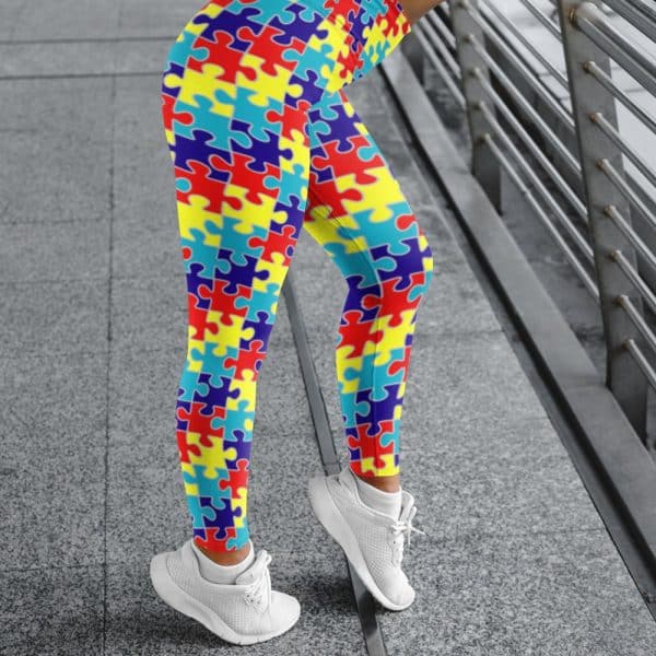Legs Wearing Bright Puzzle-Piece Patterned Leggings And White Sneakers.