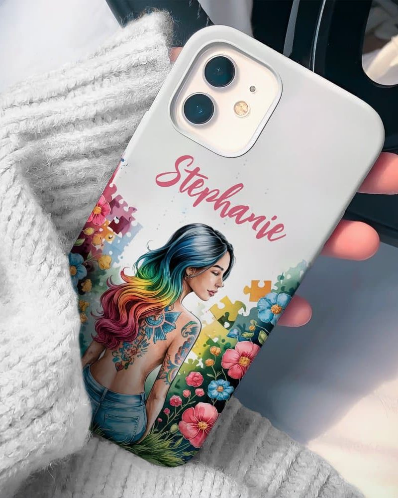 White phone case with the name Stephanie, featuring an illustration of a woman with rainbow hair and a back tattoo, surrounded by flowers and puzzle pieces.