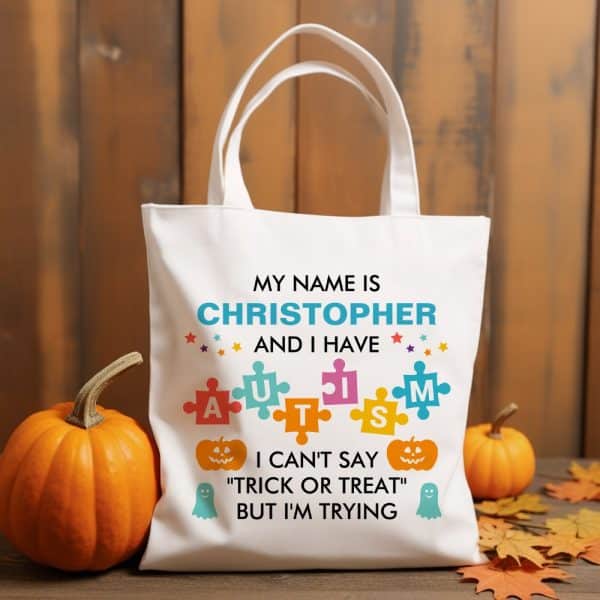 White Tote Bag With Text Saying Christopher Has Autism And Is Trying To Say Trick Or Treat.