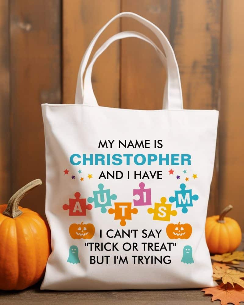 White tote bag with text saying Christopher has autism and is trying to say trick or treat.