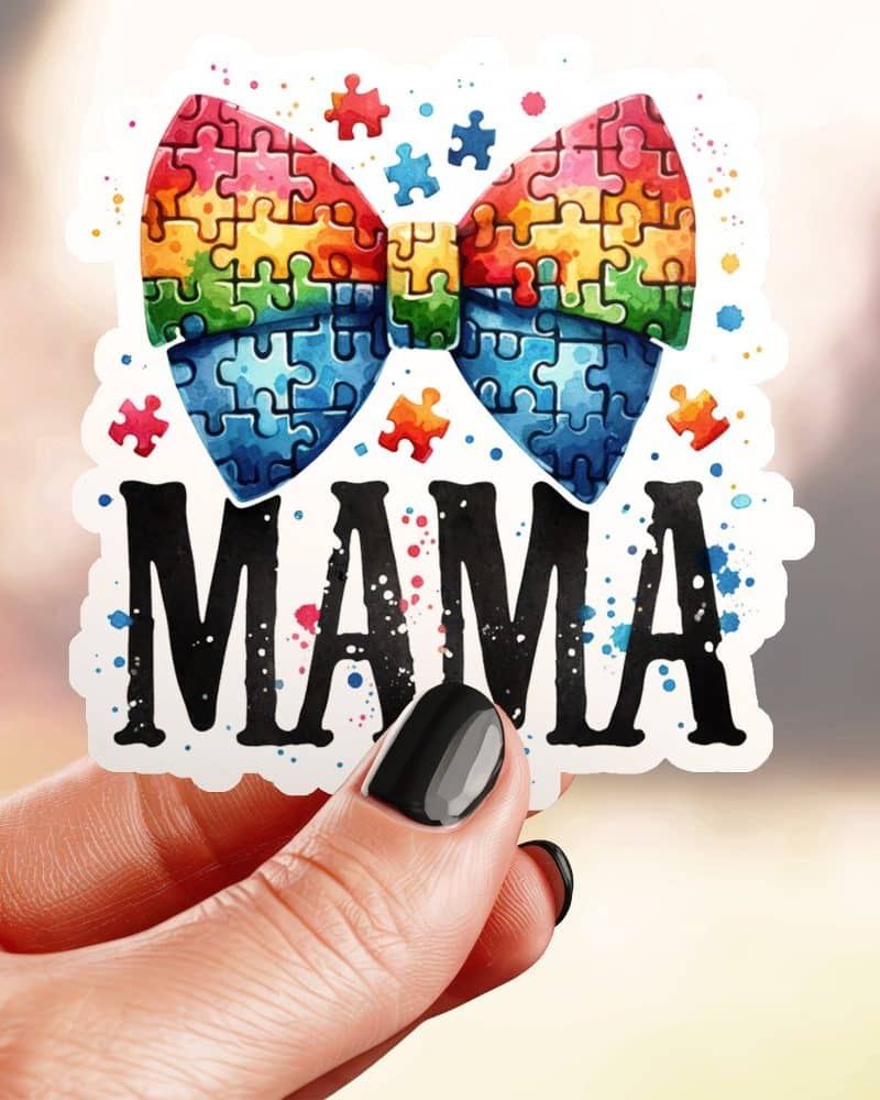 A hand holds a sticker showing a rainbow puzzle piece bow with the word Mama below it.