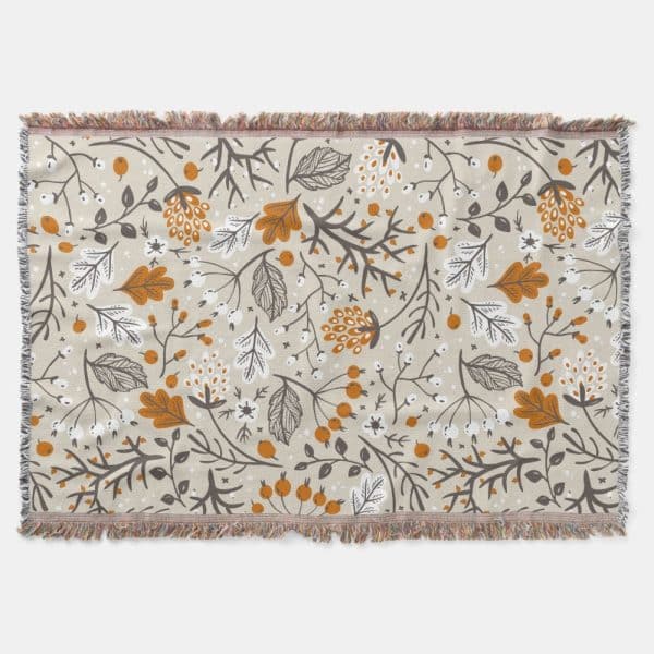Beige Woven Throw Blanket With A Repeating Pattern Of Stylized Orange And Gray Autumn Leaves And Berries.