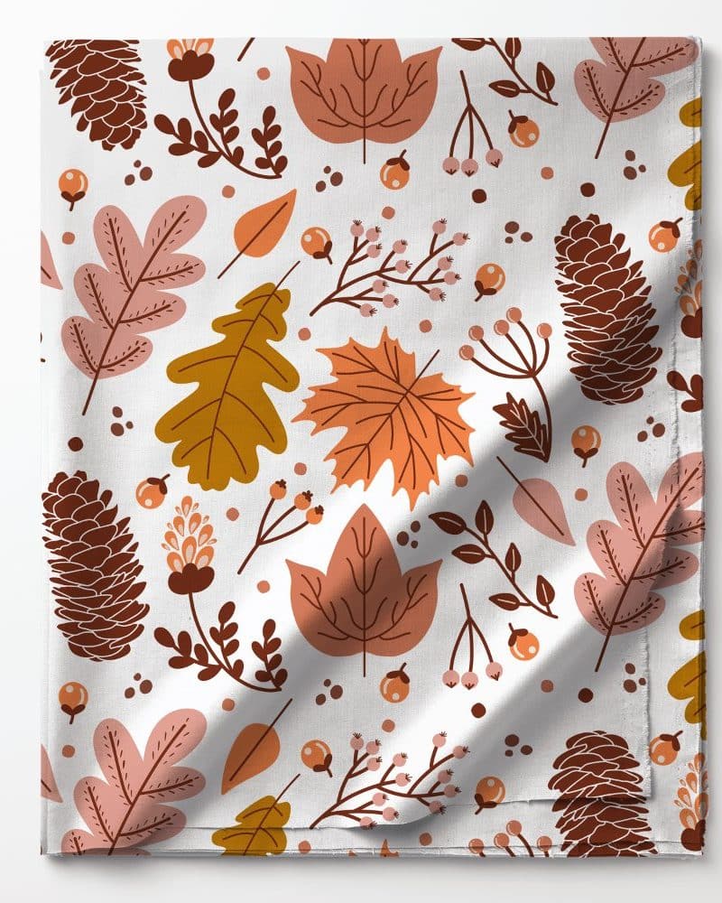 Autumn-themed fabric featuring a repeating pattern of leaves, pine cones, and berries in shades of orange, brown, and pink on a white background.