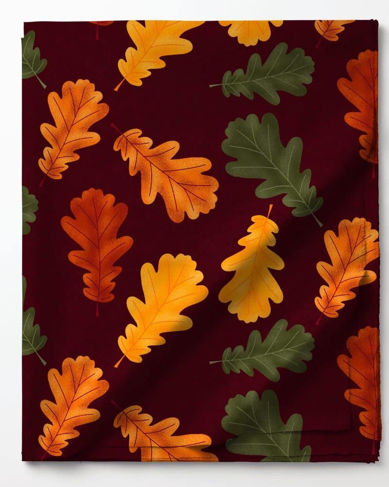 Dark red fabric with a repeating pattern of orange, gold, and green oak leaves.
