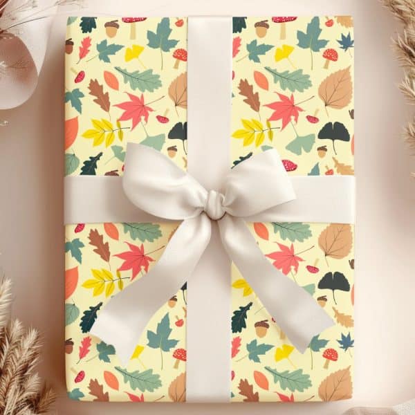 A Gift Wrapped In Autumn-Themed Paper Featuring Leaves, Acorns, And Mushrooms, Tied With A Cream-Colored Ribbon.