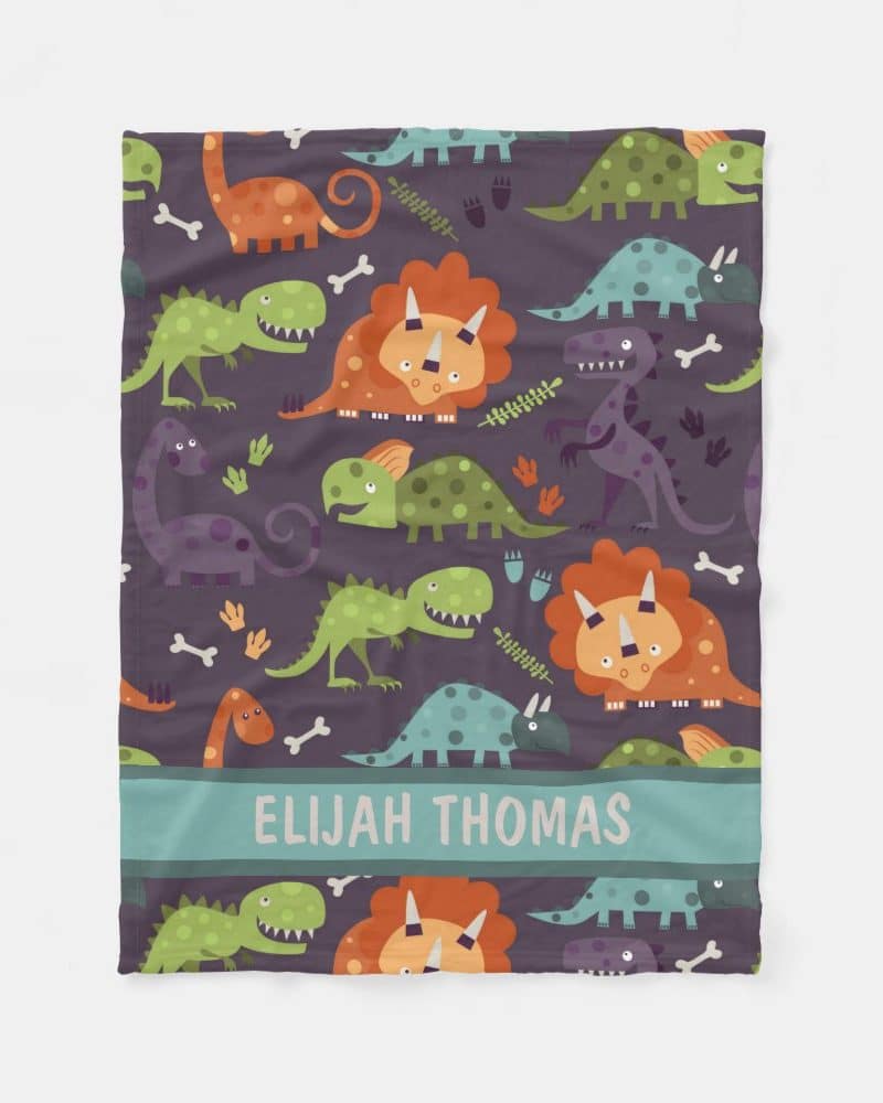 Personalized baby blanket with a colorful dinosaur pattern.