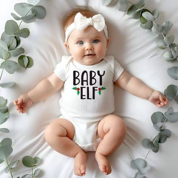 Baby Wearing A White Onesie That Says Baby Elf.