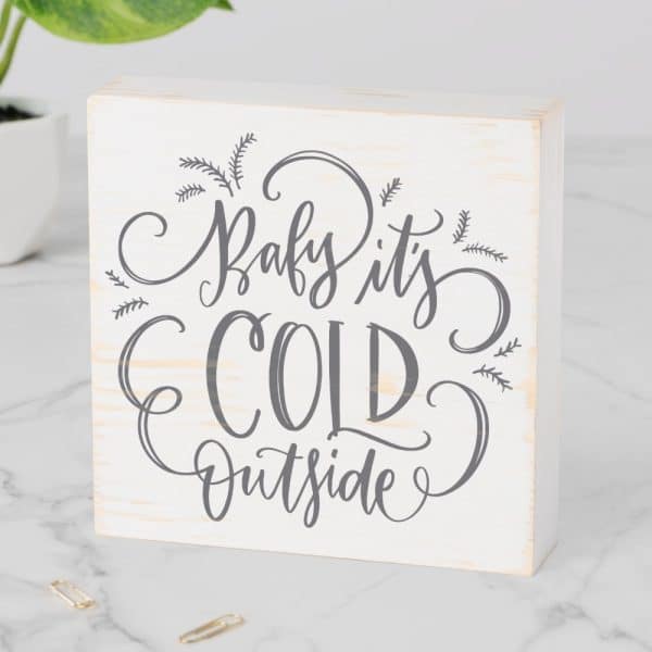 White Wood Block With Gray Lettering That Says Baby It'S Cold Outside.
