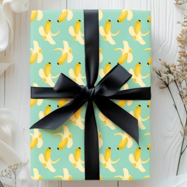 Gift Wrapped In Light Teal Paper With A Banana Pattern And Tied With A Black Ribbon.