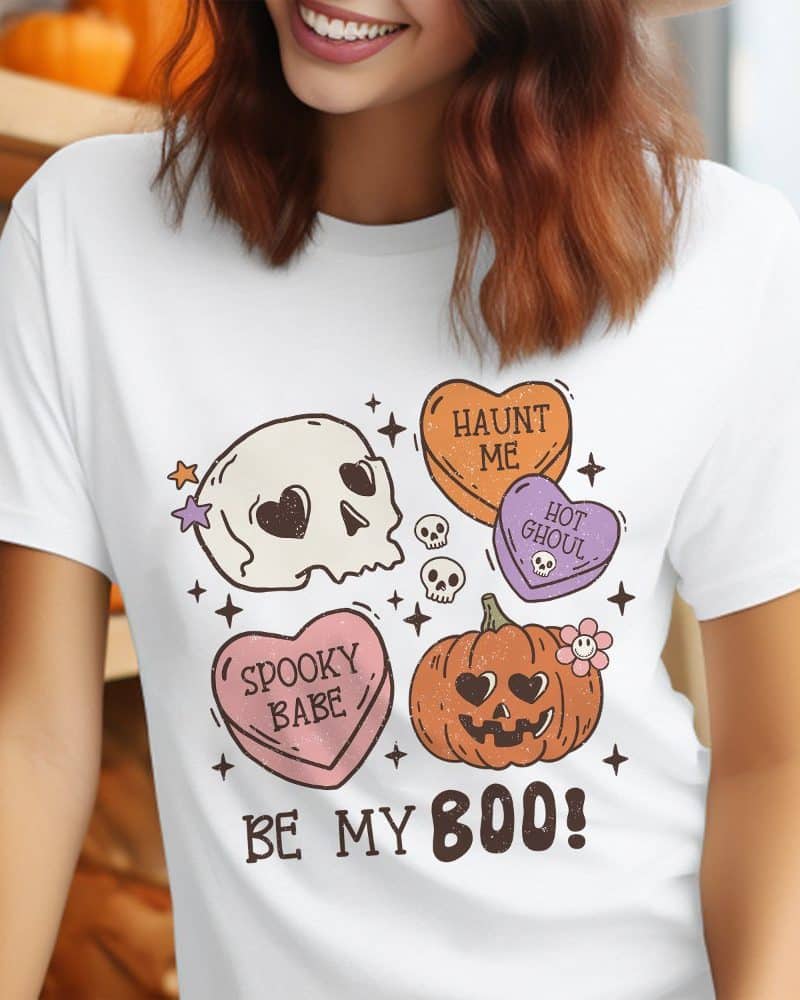 White t-shirt featuring a Halloween design with candy hearts, skulls, and a pumpkin.
