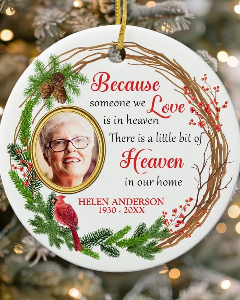 Round Christmas ornament with a photo of a woman, a cardinal, and a wreath design; text reads: Because someone we love is in heaven, there is a little bit of heaven in our home. Helen Anderson, 1930-20XX.