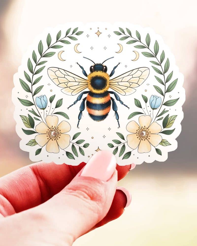 A bumblebee sticker surrounded by flowers and a crescent moon.