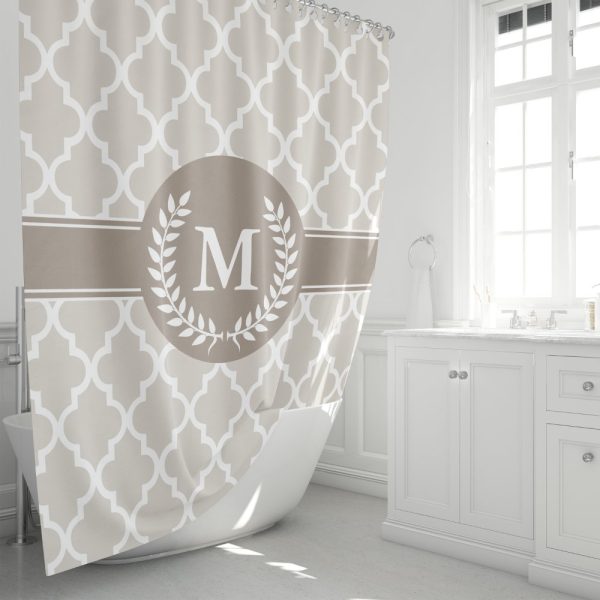 Beige Shower Curtain With A Quatrefoil Pattern And A Central Monogram Featuring The Letter M Inside A Laurel Wreath.
