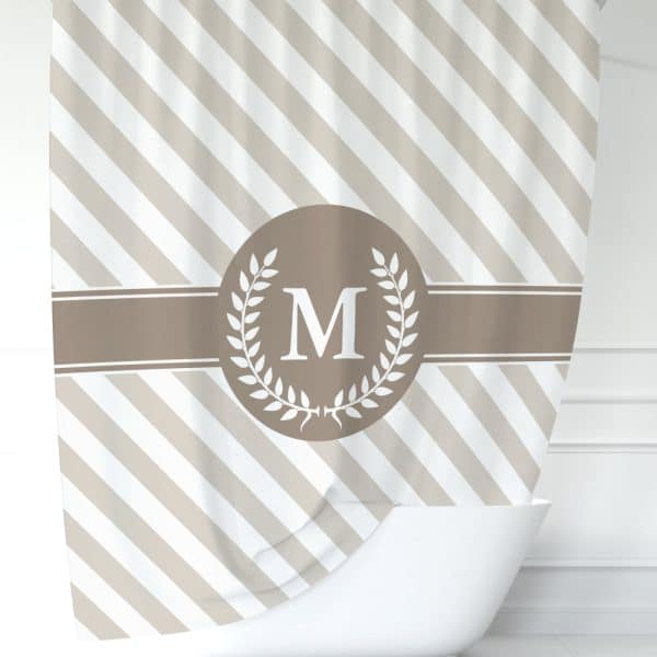 Beige And White Diagonal Striped Shower Curtain With A Taupe Circle And Laurel Wreath Design Centered, Featuring A White Capital M.
