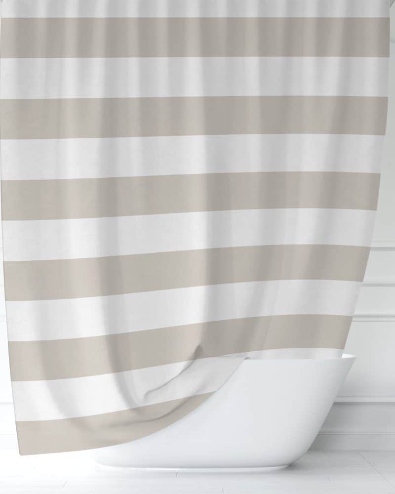Beige and white striped shower curtain partially draped over a white bathtub.