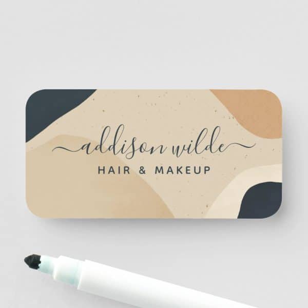 Addison Wilde Hair And Makeup Business Card With An Abstract Beige, Tan, And Dark Blue Design.
